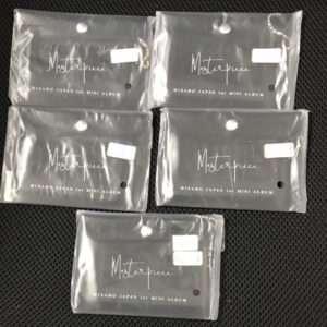 Five sealed mini album packages in clear bags on a dark surface, each labeled MISAMO JAPAN 1st MINI ALBUM with a white price sticker.