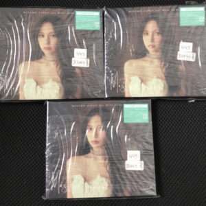 Three album covers showing a woman with long dark hair in a white lace strapless dress and choker, sealed in plastic on a dark textured surface, each with a green sticker and handwritten price tags.
