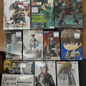 Row of boxed anime figures on a wooden floor, including Yu Yu Hakusho’s Yusuke Urameshi and other character boxes.