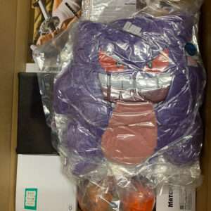 Purple plush toy with an angry face, wrapped in plastic inside a cardboard box.