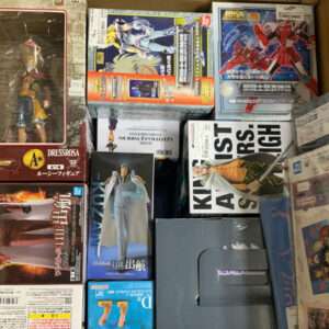 Box filled with assorted anime figure boxes stacked in a storage carton.