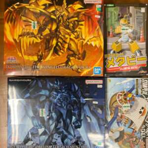 Boxed Bandai model kits featuring Egyptian God figures: Ra with golden winged dragon in fiery orange packaging (Egyptian God - The Winged Dragon of Ra).