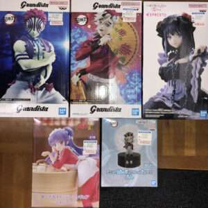 Three Demon Slayer Grandista figures in boxes: Akaza on the left, Zenitsu in the middle with a fan, Nezuko on the right with her chains and purple dress design.  Articulos Japan (Post Box Japan)