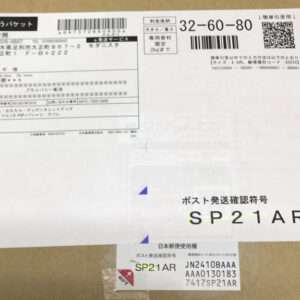 Parcel with Japanese shipment labels and barcodes; large SP21AR tracking code visible on the label area of the box.