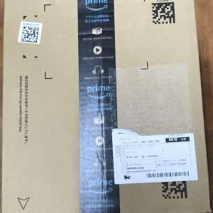 Brown Amazon Prime package with vertical black Prime tape, delivery label, and QR codes on the front. Casual packaging for shipping.