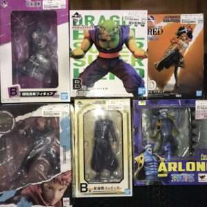 Collection of six boxed action figures from anime series (Dragon Ball, One Piece) arranged on a floor; visible colors include purple, green, and orange boxes with character poses.
