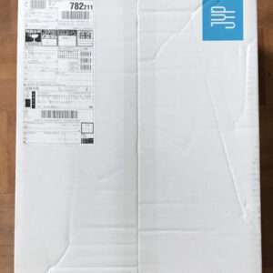 White cardboard shipping box with a large label and barcodes on the left side; a blue sticker with a white logo on the top-right corner.