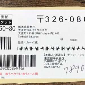 Japanese postal shipping label with multiple barcodes, Japanese text, and handwritten numbers; used for mail delivery on a small parcel.