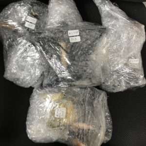Bundle of items wrapped in bubble wrap, with price labels in yen visible (e.g., ¥1,738 and 715).