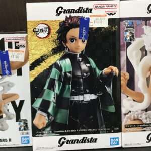 Three Grandista figures on a store shelf: Luffy Gear 2 on the left, Tanjiro Kamado in the center, and Luffy Gear 5 on the right.