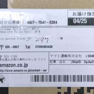 White shipping label on a cardboard box with Japanese text, date 04/25, barcode, and address blocks for sender and recipient.