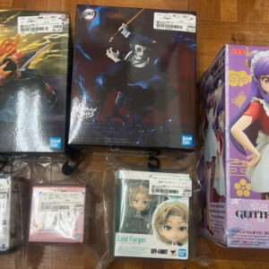 Collection of anime figure boxes on a wooden floor, including a large purple-haired character in a maid outfit on the right and two big boxes on the left.  Articulos Japan (Post Box Japan)