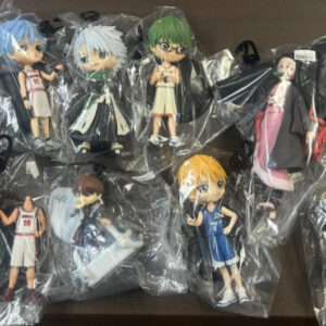Assorted chibi anime figurines in plastic bags laid out on a table, each in colorful outfits, forming a collection display.