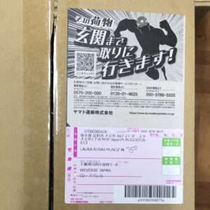 Box with a large black-and-white warning graphic and a QR code on the shipping label; pink recipient form and barcode visible underneath.