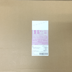 Cardboard box with a small pink shipping label centered on the surface.