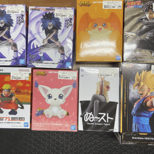 Row of boxed anime action figures on a dark textured floor, featuring characters from Naruto and Dragon Ball among others.