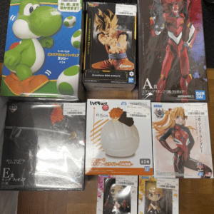 Boxed Yoshi figure and other anime figures on a wooden floor, variety of colorful characters boxed for display sale