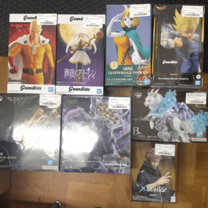 Row of boxed anime figures on a wooden floor, featuring Dragon Ball and other anime characters.  Articulos Japan (Post Box Japan)