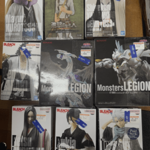 Row of Bleach action figure boxes on a wooden table, each with character portraits and price tags visible.