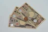 Close-up of Japanese Yen banknotes and coins arranged on a flat surface.  Articulos Japan (Post Box Japan)