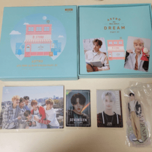Two pastel blue Astro DREAM album boxes with photos and cards laid out on a table.