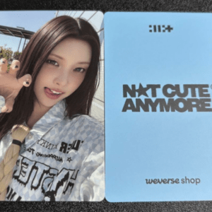 Two-sided card: left side shows a young woman taking a selfie with painted nails, wearing a patterned shirt and tie; right side is blue with 'NCT CUTE ANYMORE' and 'weverse shop'.