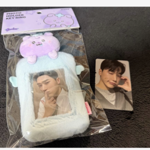 Blue fluffy photo holder key ring with a clear window showing a man's photo and a purple bunny topper on top.