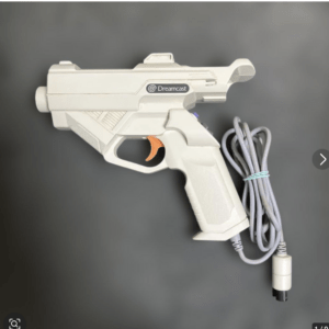 White Dreamcast light gun controller with orange trigger and attached gray cable, branded with the Dreamcast logo.