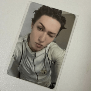 Young man with wet hair in a light gray hoodie winking at the camera in a close-up selfie frame
