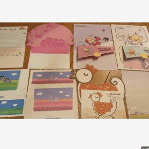 Collection of cute animal-themed note cards and envelopes spread on a wooden table.
