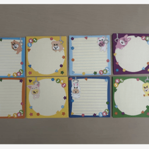 Nine small colorful notepads arranged in a 3x3 grid, each with cartoon animal corners and lined or grid pages for kids.