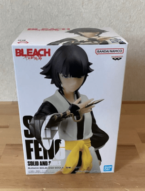 Box for a Bleach Solid Figure action figure, showing a female character with black hair in a white and black outfit and a yellow belt, posed on the box with 'Bleach' branding visible.