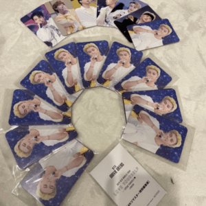 Set of glossy photo cards arranged in a spiral on a light surface; each card features a young man in a white outfit posing with a microphone against a blue starry background.