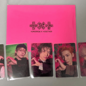 Pink folder with a black logo reading 'Tomorrow X Together' and five photo cards of group members posing with heart hand gestures.