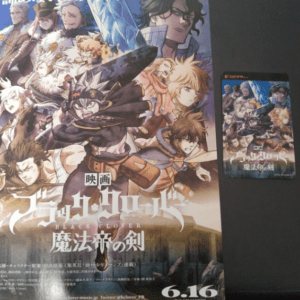 Colorful poster for the Black Clover movie, featuring multiple armored characters wielding swords and magic, with the title in Japanese and English ('Black Clover: 魔法帝の剣'); a smaller card version sits to the right against a dark background.