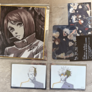 A collection of anime character cards on a beige surface: a large portrait of a brown-haired girl in a yellow-framed sleeve at left.