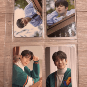 Four photo cards featuring a young man in casual outfits, arranged in a clear plastic sleeve on a wooden surface.