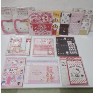 Assorted pink Hello Kitty and Sanrio stationery sets arranged on a table.