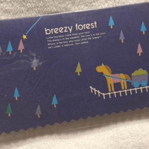 Blue postage stamp with jagged edges, showing a yellow horse pulling a cart under stylized trees; text reads 'breezy forest' with a short verse.