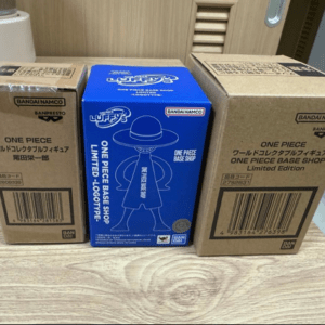 Three boxed One Piece figure sets arranged on a wood surface: brown boxes on the sides and a blue Base Shop Limited Edition box in the center with a Luffy silhouette.|center blue box shows Luffy in a hat, flanked by two brown boxes