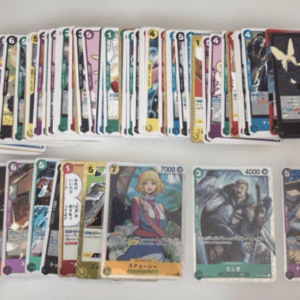 Row of colorful trading cards laid out on a table, some with anime artwork and numbers visible on the borders.