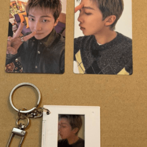 Two printed photos of a young man making a peace sign and a side profile, placed on a corkboard, with a keychain and small photo frame nearby.