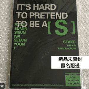 Black StayC 5th single album cover with bold white title and large green [S]; green artist names on left and Japanese text overlay typed on a white label.