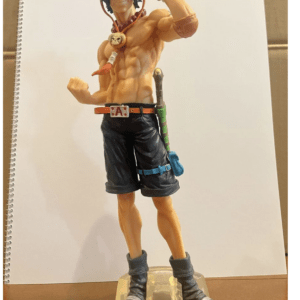 Poseable plastic action figure of a shirtless pirate wearing a red hat, black shorts, boots, a skull necklace, and a sheathed sword.