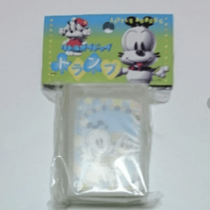 Plastic-wrapped cartoon character toy in a clear bag, with a bright blue-green packaging showing a white rabbit and a small dog on top.