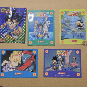 Six Dragon Ball GT trading cards laid on a tan surface, showing colorful character illustrations and logos.