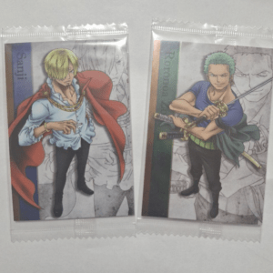 Two anime character cards in clear plastic sleeves, Sanji on the left with blond hair and a red cape, Zoro on the right with green hair and swords.