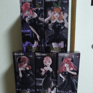 Stacked BiCute Dark Figure boxes featuring anime girls in black gothic outfits, with two tall boxes on top and three on the bottom against a light wall.