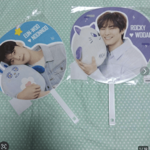 Two round fans featuring photos of a smiling man with a plush cat on a blue background and a second man with a white plush cat on a purple background.