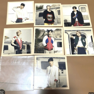 Collage of eight Polaroid-style photos showing a young man in retro jackets posing beside a camper trailer, spread on a tan surface.